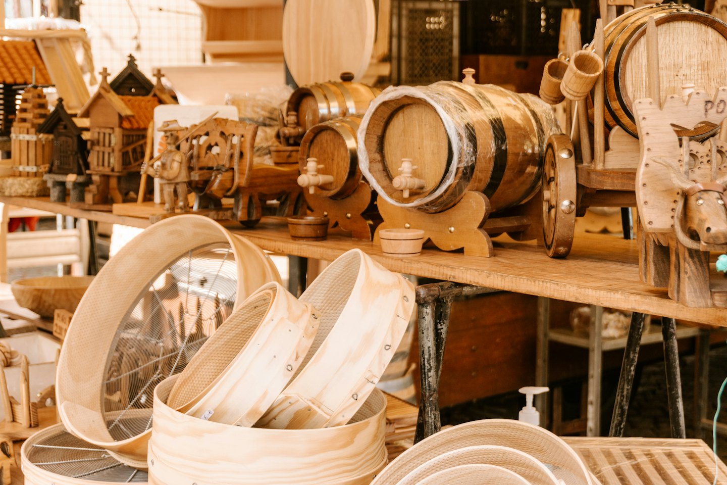Wooden crafts like barrels and figurines displayed on market shelves.