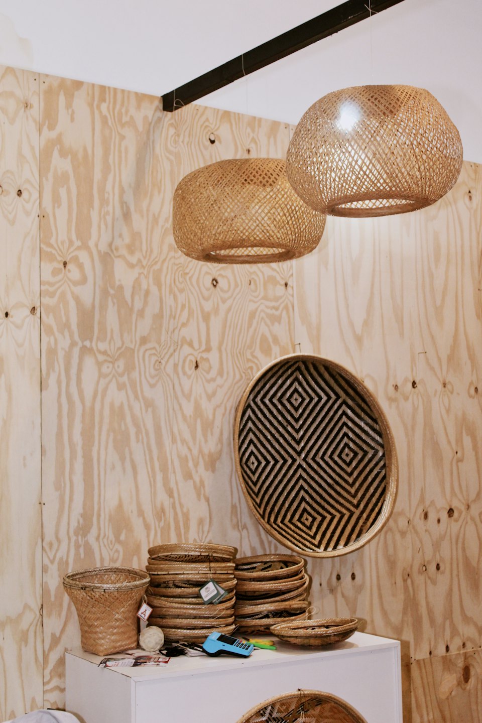 Handcrafted woven baskets and rattan light fixtures displayed in a shop.