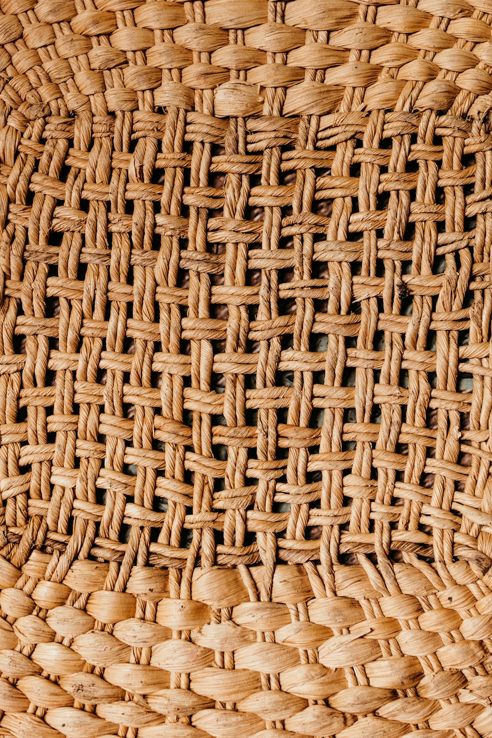 Woven straw fabric displays two distinct overlapping weaving patterns.